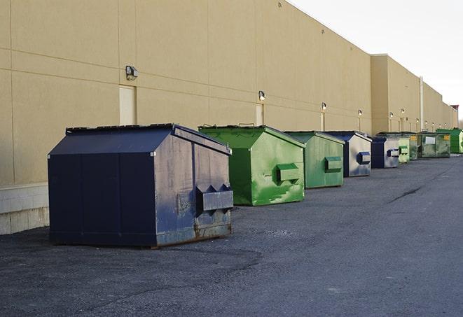 a compact construction dumpster being emptied by a waste disposal truck in Great Falls